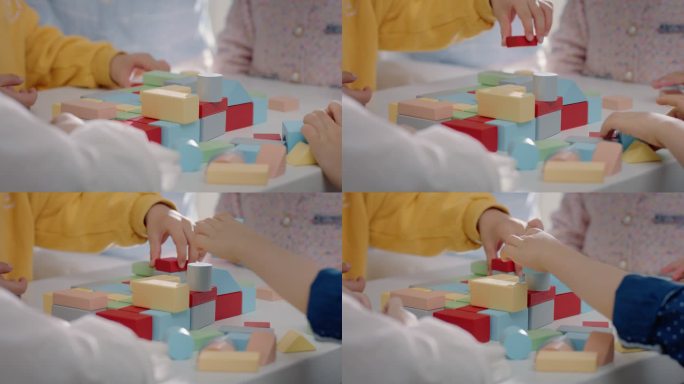 小孩小朋友一起在桌子上玩彩色的积木