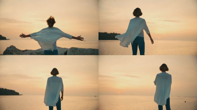在克罗地亚罗维尼的日落时分，无忧无虑的女游客伸开双臂站在海边的岩石上跑步