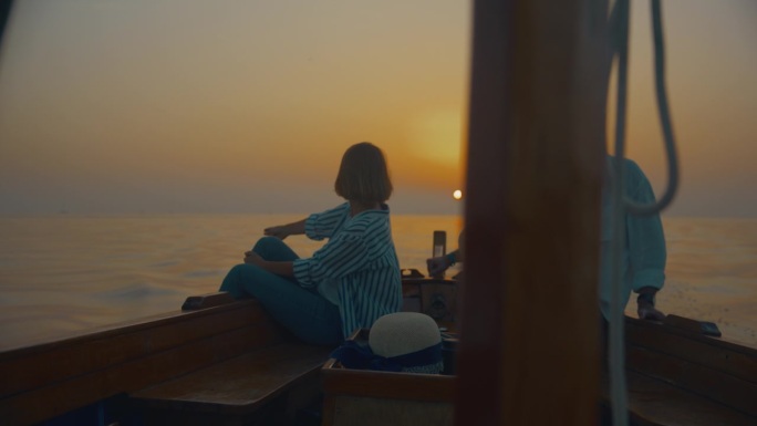 SLO MO航行宁静:一对夫妇在帆船的船头欣赏日落