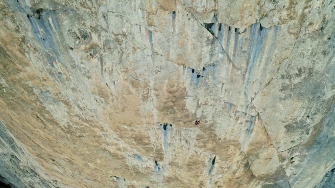 惊险的冒险:一个男人顺着岩石上的绳子往下爬
