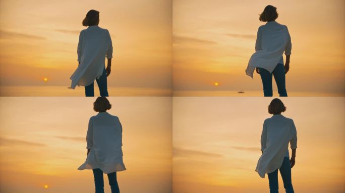 在克罗地亚罗维尼，手持拍摄的女性游客在日落时站在大海上广阔的橙色天空下