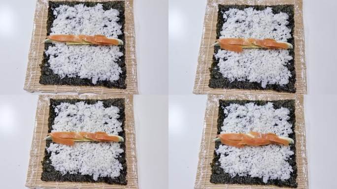 厨师在做寿司时把米饭和三文鱼放在海苔片上