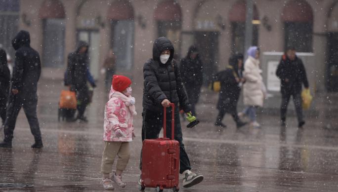 大雪中火车站的母女二人