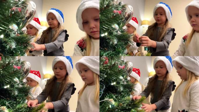三胞胎中的三个小姐妹用玩具和花环装饰圣诞树