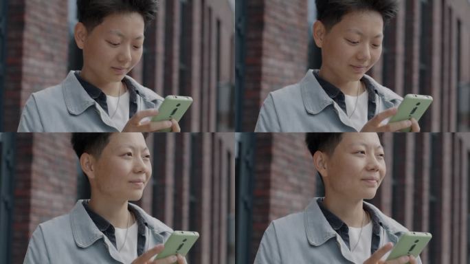 无忧无虑的亚洲学生站在城市街道外，用智能手机触屏享受社交媒体