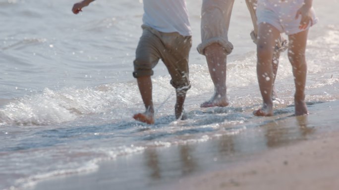 男女小孩在海边玩水奔跑打湿了裤脚