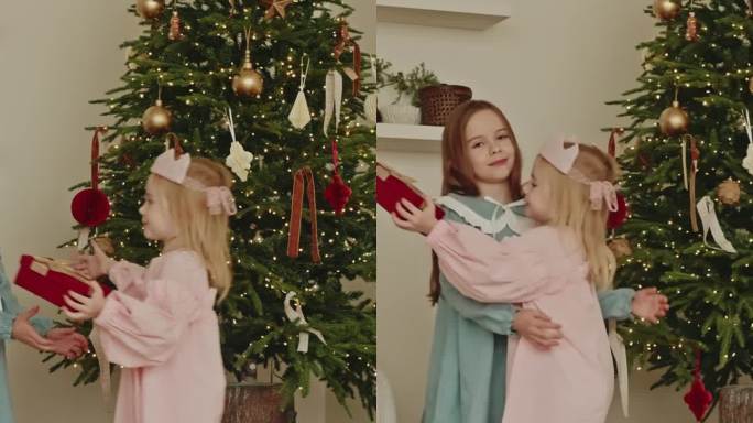 两个小女孩姐妹互赠礼物，互相拥抱，合家欢乐，新年快乐