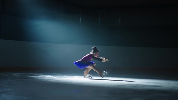 可爱的小女孩在溜冰场滑冰，轮廓在明亮的软衣，慢动作镜头