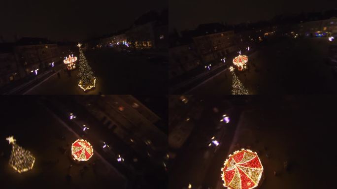 FPV无人机在夜晚飞行，在充满装饰和圣诞彩灯的老城上空