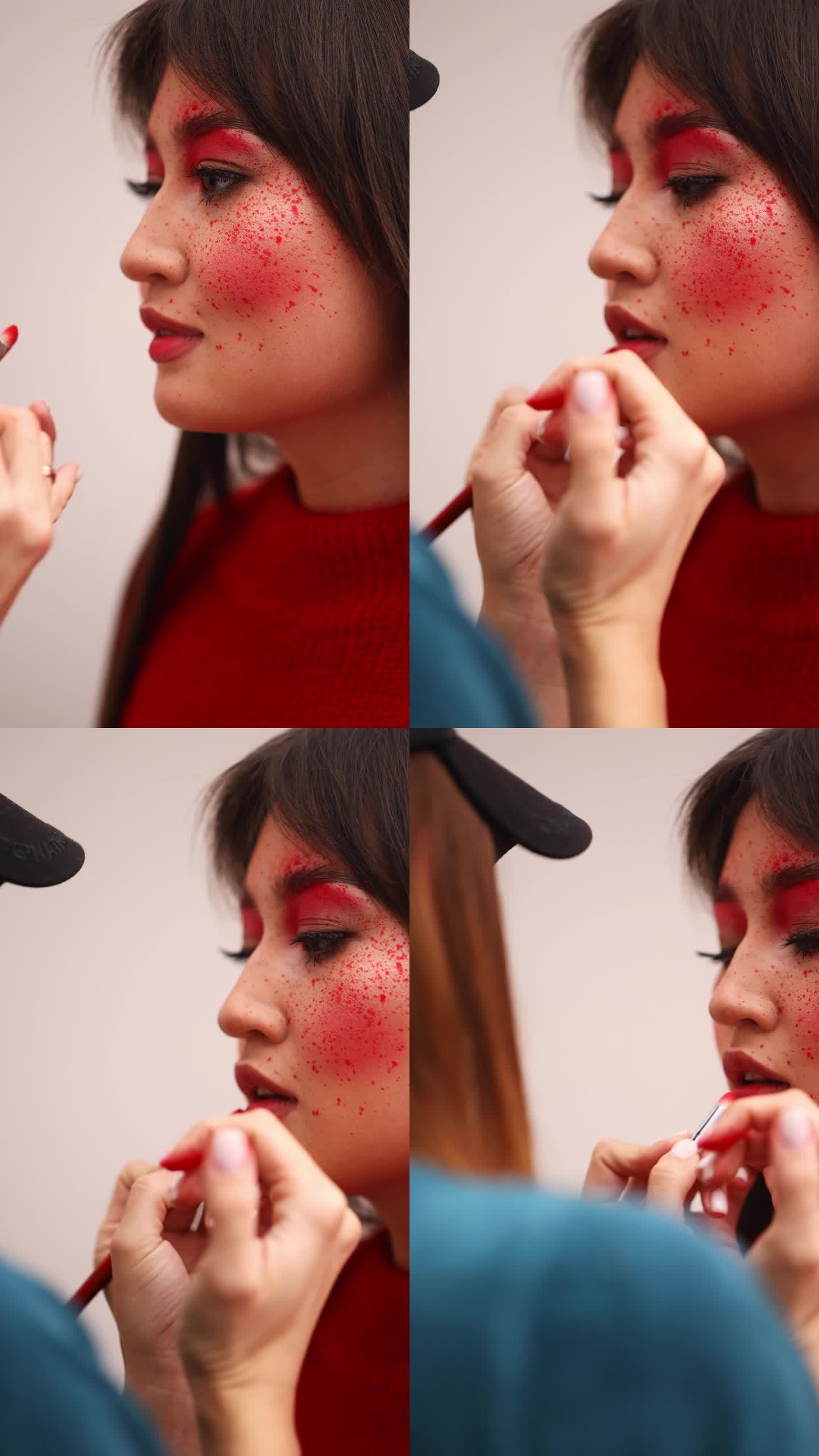 用红色的骨头画嘴唇。一个亚洲女孩的化妆模特。垂直视频。红滴腮红