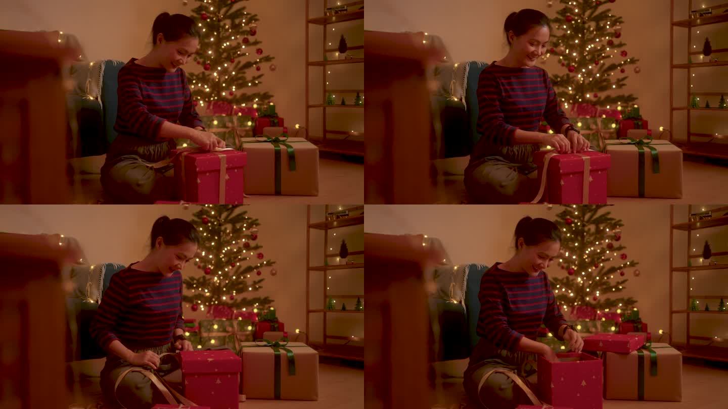 一名亚洲女子在圣诞夜打开礼盒时惊喜万分。