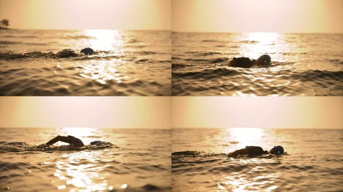 坚定的女人在日落时在阳光反射的天空中游泳。开放水域游泳者