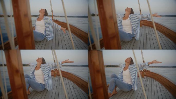 漂浮的宁静:一个女人在帆船的甲板上举起双臂，享受着这一刻