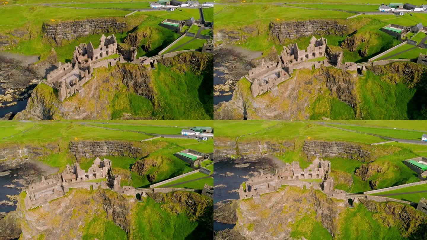 在北爱尔兰的邓卢斯城堡上空逆时针旋转的航拍轨道