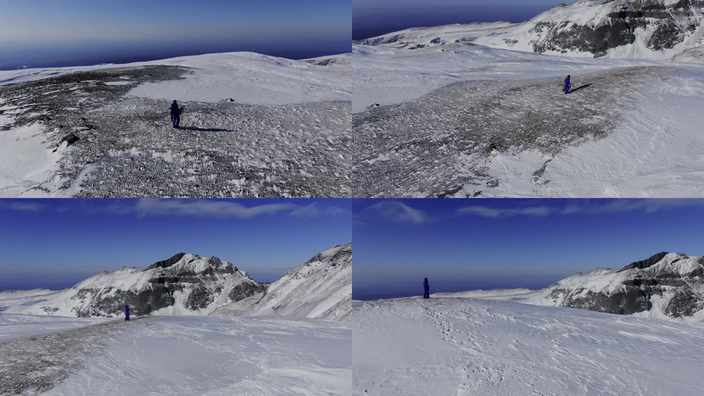 航拍人拿着滑雪装备在长白山雪山行走