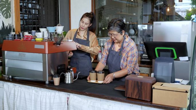 亚洲老年;年轻的咖啡师在咖啡机上工作，店主在帮顾客倒咖啡。咖啡厅餐饮服务小企业主餐饮行业的概念。