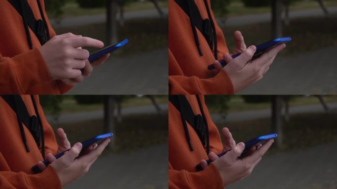街头少年手中的蓝色智能手机特写。