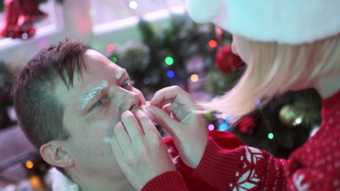 圣诞装化妆师在给男演员化妆时粘胡子