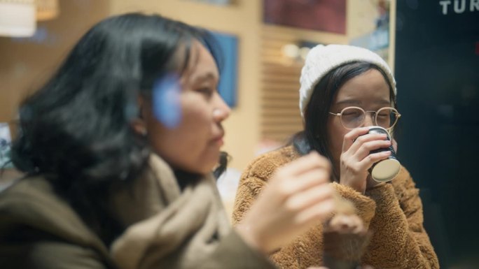 两个年轻的女游客坐在餐馆里谈论在日本的旅行。
