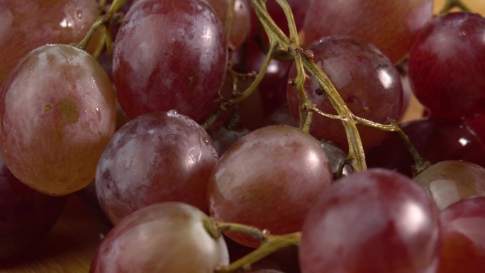 葡萄特写，概念酿酒，葡萄酒生产，葡萄品种。新鲜的一串串红色或粉红色的葡萄作为背景旋转
