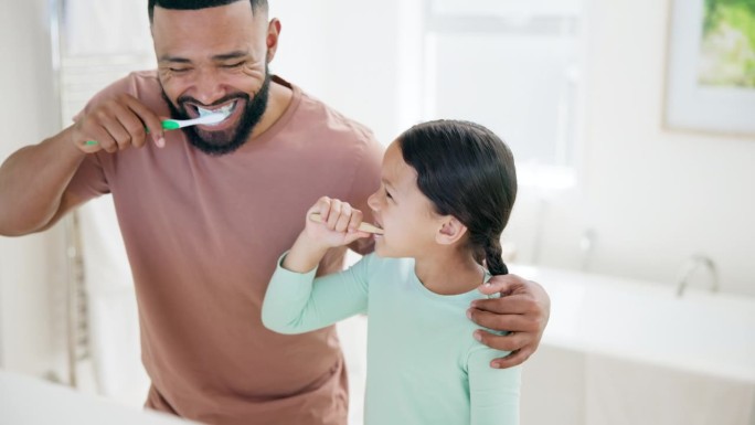 快乐的父亲，孩子和在浴室刷牙的牙齿保健，卫生或早上例行公事一起在家里。爸爸和小女孩或孩子用微笑清洁牙