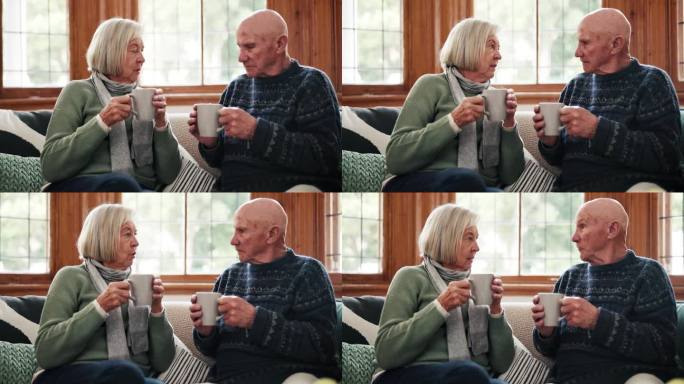 爱，咖啡和老夫妇在沙发上聊天在客厅放松，联系和交流在家里在一起。喝茶时，休息时与老人闲谈、交谈或退休