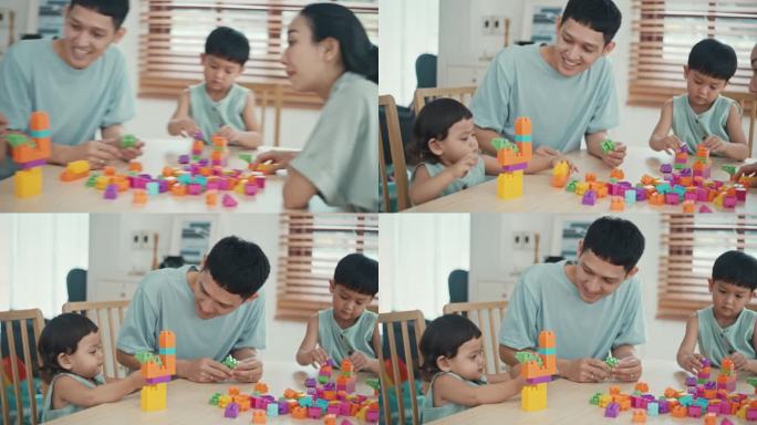 幸福的一家人，儿子和女儿在家里玩五颜六色的塑料积木