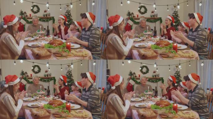 一个亚洲家庭在圣诞节期间为年长的父母举行生日聚会。可爱的时刻，家人唱生日歌给老人，然后在家里餐桌上吹
