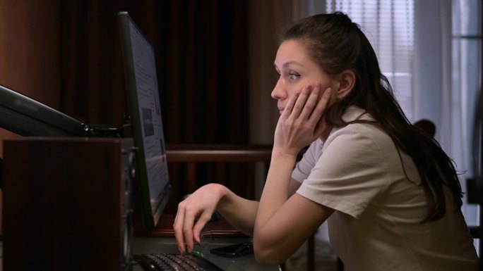 女人在电脑上看新闻，对世界上正在发生的事情感到惊讶