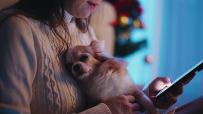 亚洲女性喜欢在客厅和宠物一起放松时使用她的智能手机