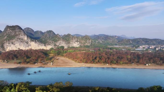 早晨阳光下桂林漓江边的山和水面上的竹筏