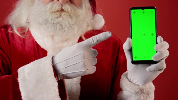 匿名圣诞老人指着绿屏智能手机