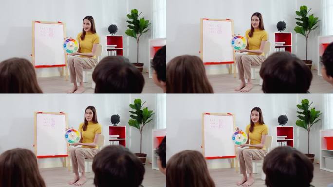 亚洲美女老师用一个时钟来显示时间是如何过去的，并问她的学生的时间，一个亚洲女教练正在指导不同种族的学