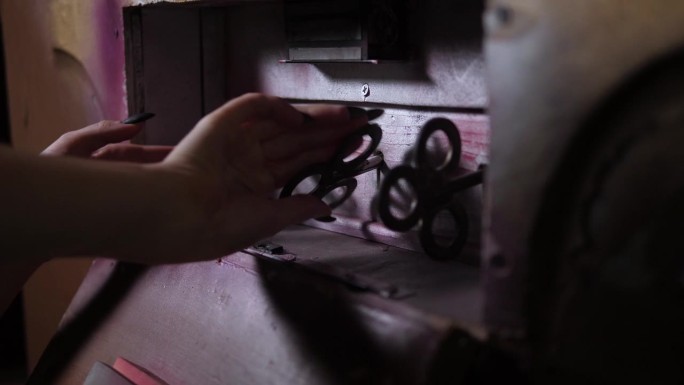 一个女孩的特写镜头打开了一个装有三把古董大钥匙的木制抽屉。