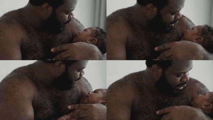 非洲父亲在家里抱着他的孩子。