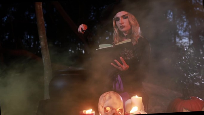 一个迷人的女巫在森林里念了一个咒语并读了一本魔法书。森林里的魔法。万圣节的概念