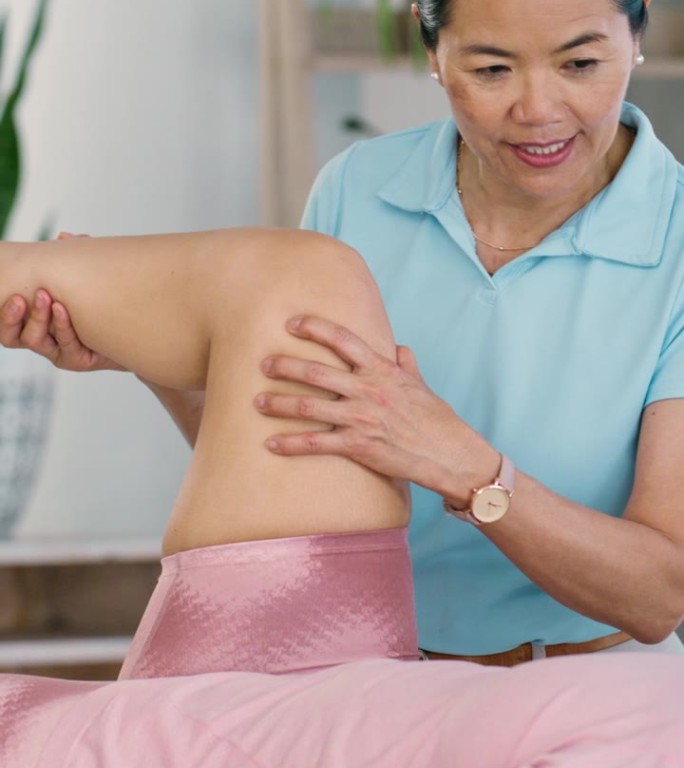 理疗师、保健人员和在脊椎指压康复中心做理疗运动的妇女。成熟的医务工作者在诊所帮助病人增强腿部力量和活