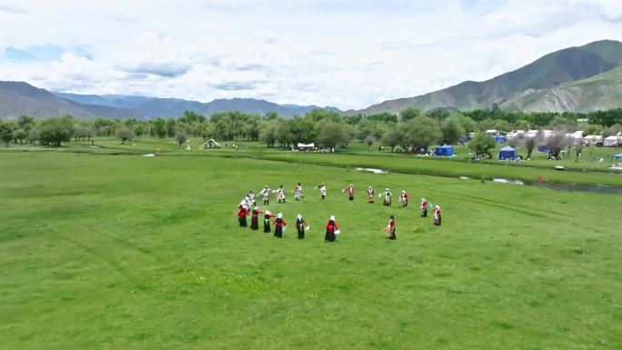 在草地上跳锅庄的藏族同胞