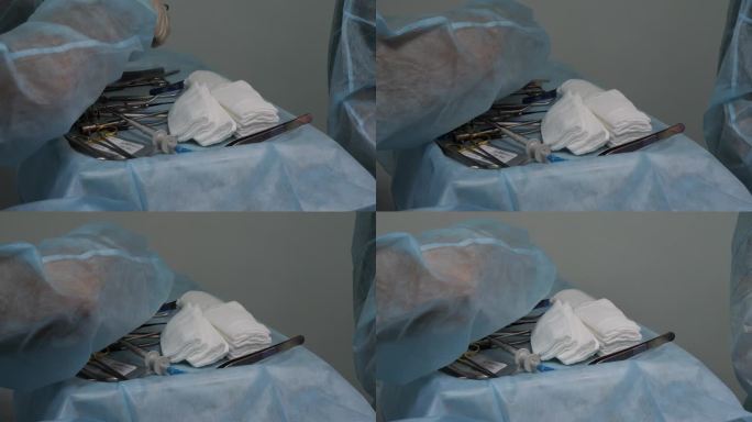 护士把无菌的手术器械放在桌子上，递给外科医生。在外科手术中，各种手术器械被放置在无菌尿布上。