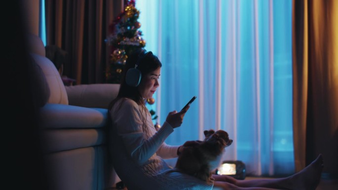亚洲女性喜欢在客厅和宠物一起放松时使用她的智能手机