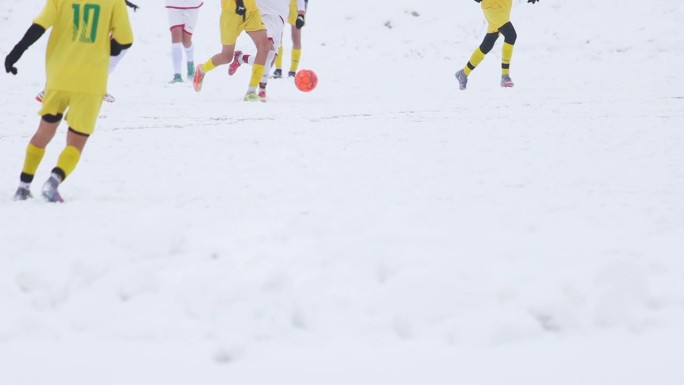 足球运动员在雪地里追球