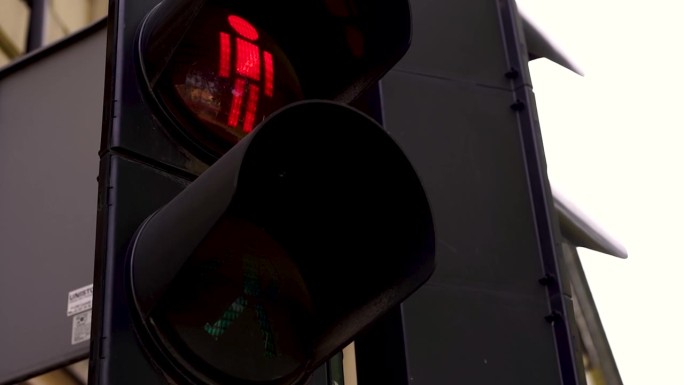 大型城市十字路口红绿灯特写，调节行人在街道上的移动，使道路上的人安全移动。道路设备交通管制。交通灯变