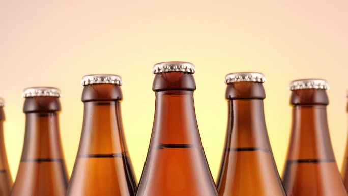 啤酒瓶的特写。棕色的玻璃瓶装满了金色的啤酒，体现了酒精饮料的本质，夏季的茶点，以及啤酒节的精神