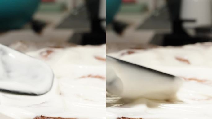 垂直视频。糕点师用黑色抹刀在蛋糕上涂上白奶油。