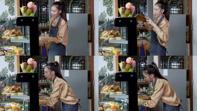 美丽的亚洲女咖啡师在点菜时与顾客交谈。系着围裙的年轻女子站在木制柜台前，给顾客端上咖啡和甜点蛋糕。