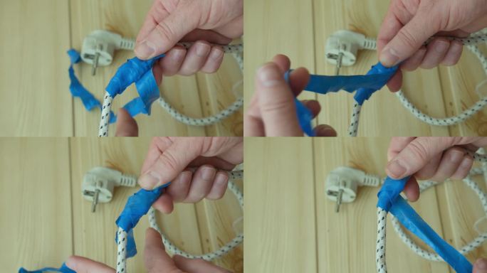 用蓝色绝缘胶带自己动手修理损坏的电线。