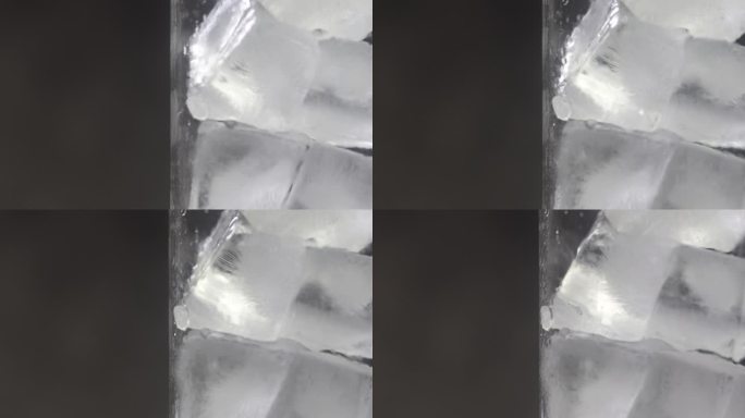 冰块放在透明玻璃中，在黑光背景下旋转拍摄。