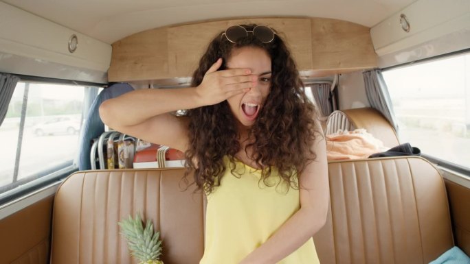 美丽的十几岁的潮朋友摆姿势拍照女孩吹吻微笑在节日在露营车的公路旅行冒险