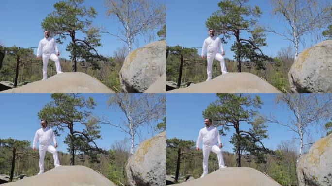 男歌手在大自然中间的山顶上演唱敏感的歌曲。身穿白色衬衫的大胡子歌手一边唱歌一边张开双手
