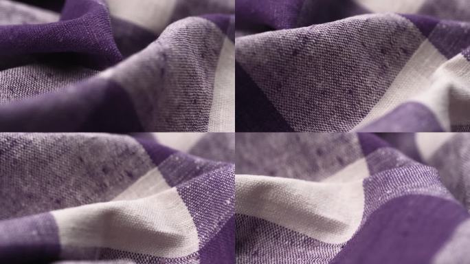 白色和紫色大格子图案的天然亚麻平纹织物特写旋转。